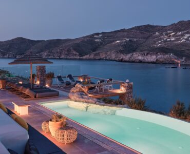 Infinity pool with sun loungers and views over Ftelia bay (view 10) at Bali Sea Front Villa in Ftelia, Mykonos