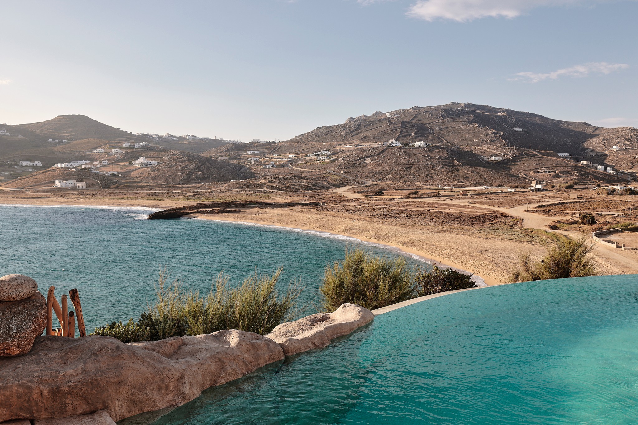 Infinity pool with sun loungers and views over Ftelia bay (view 11) at Bali Sea Front Villa in Ftelia, Mykonos
