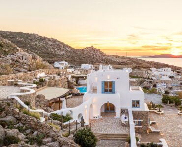 Cycladic main villa and stone-walled grounds at sunset – Grand Kanalia estate for sale in Kanalia, Mykonos