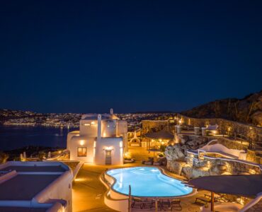 Infinity pool and terraces lit at night – Grand Kanalia estate for sale in Kanalia, Mykonos