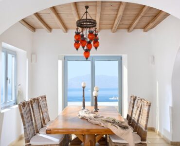 Dining room with sea view under a wooden-beam ceiling – Grand Kanalia estate for sale in Kanalia, Mykonos