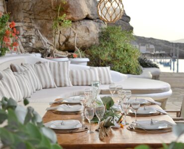 Outdoor lounge and dining table among the granite rocks – Grand Kanalia estate for sale in Kanalia, Mykonos
