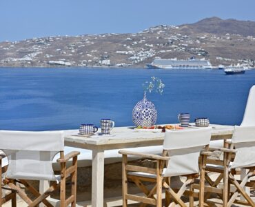 Terrace dining table with views over the bay and Mykonos Town – Grand Kanalia estate for sale in Kanalia, Mykonos