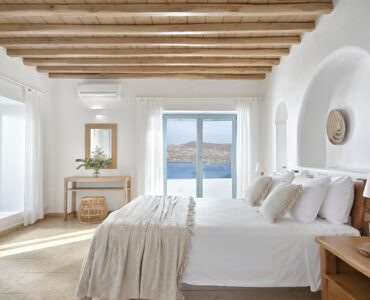 Master bedroom with timber ceiling and sea-view windows – Grand Kanalia estate for sale in Kanalia, Mykonos