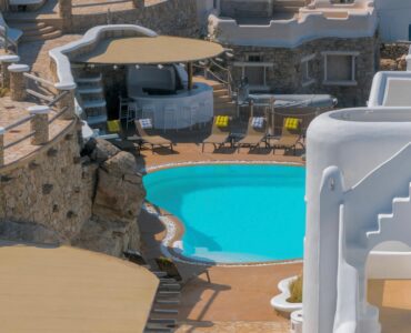 Curved infinity pool beside the whitewashed villa from above – Grand Kanalia estate for sale in Kanalia, Mykonos