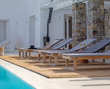 Pool deck with sun loungers at Maison Haute in Aleomandra, Mykonos