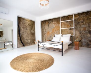 Bedroom with stone wall at Maison Haute in Aleomandra, Mykonos