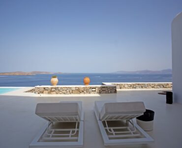 Sun loungers on the pool terrace with sea view at Maison Haute in Aleomandra, Mykonos