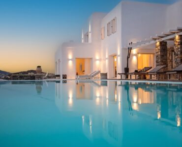 Villa lit at dusk reflected in the pool at Maison Haute in Aleomandra, Mykonos