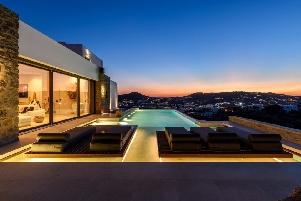 Pool lit at dusk with sunset view at Muse Mansion in Agios Lazaros, Mykonos