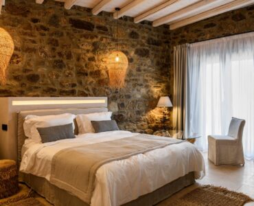 Bedroom with stone wall at Muse Mansion in Agios Lazaros, Mykonos