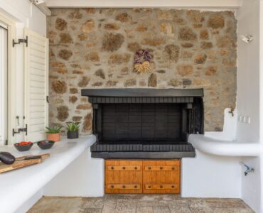 Living room with stone fireplace at Platinum Deluxe Villa in Kalafatis, Mykonos