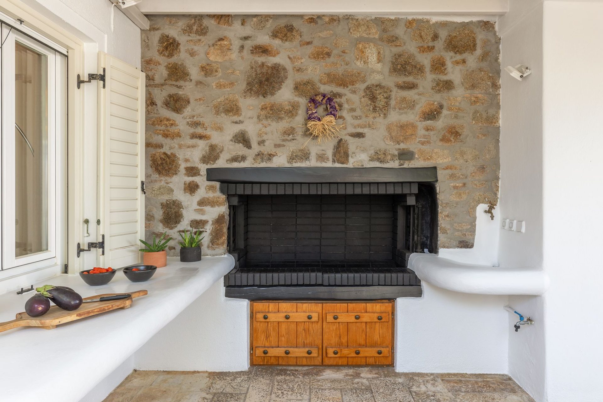Living room with stone fireplace at Platinum Deluxe Villa in Kalafatis, Mykonos