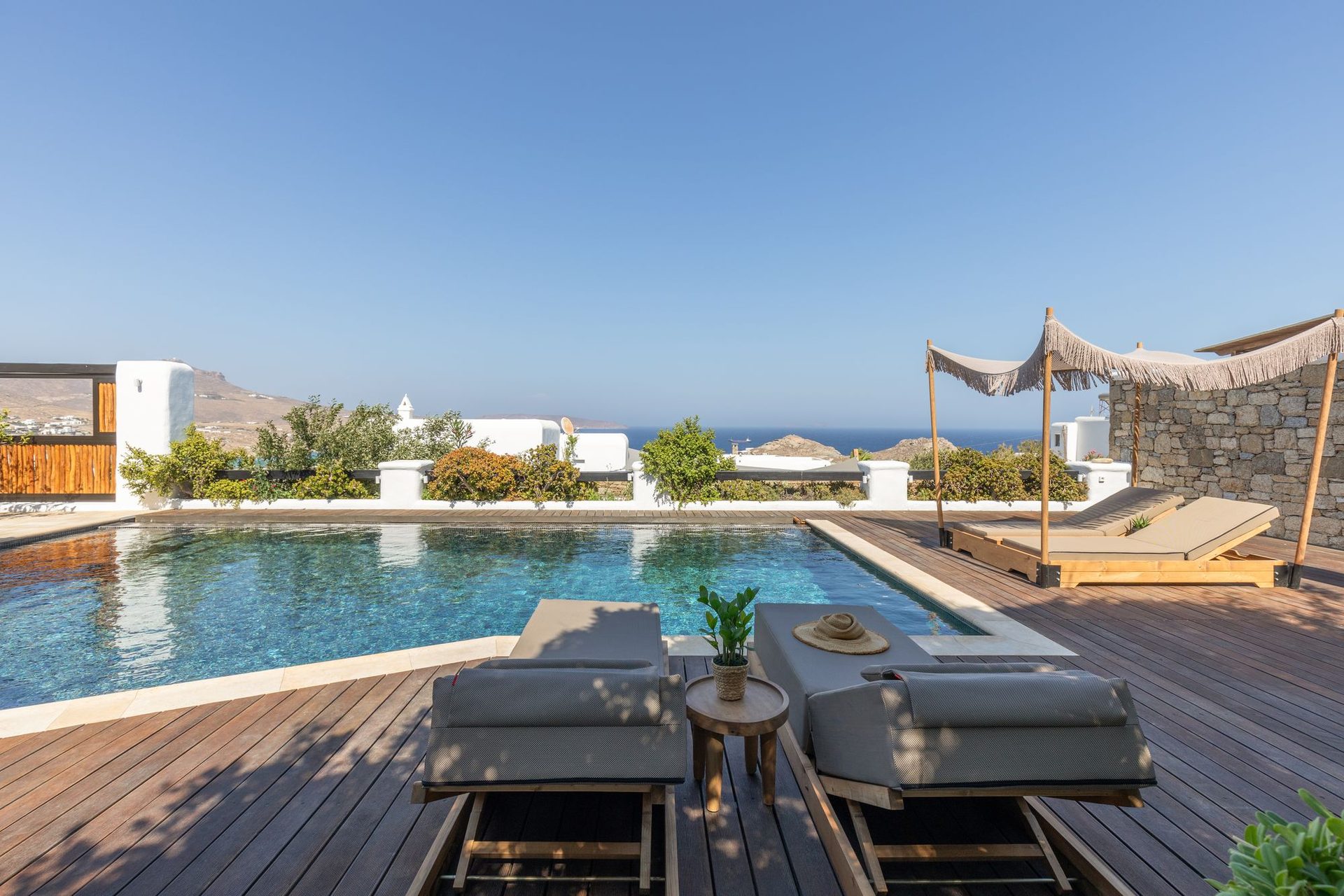 Pool deck with sun loungers at Platinum Deluxe Villa in Kalafatis, Mykonos