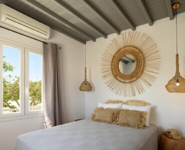 Bedroom with rattan mirror at Platinum Junior Villa in Kalafatis, Mykonos