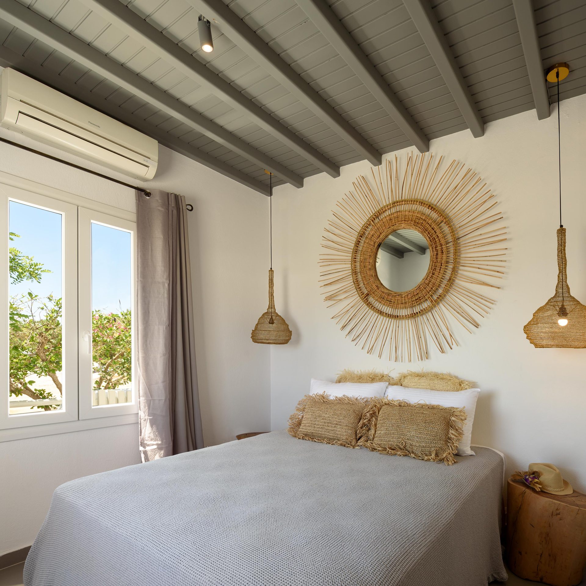 Bedroom with rattan mirror at Platinum Junior Villa in Kalafatis, Mykonos