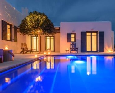 Pool lit at dusk at Platinum Senior Villa in Kalafatis, Mykonos