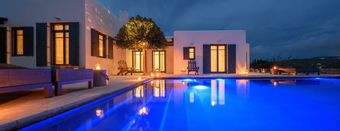 Pool lit at dusk at Platinum Senior Villa in Kalafatis, Mykonos