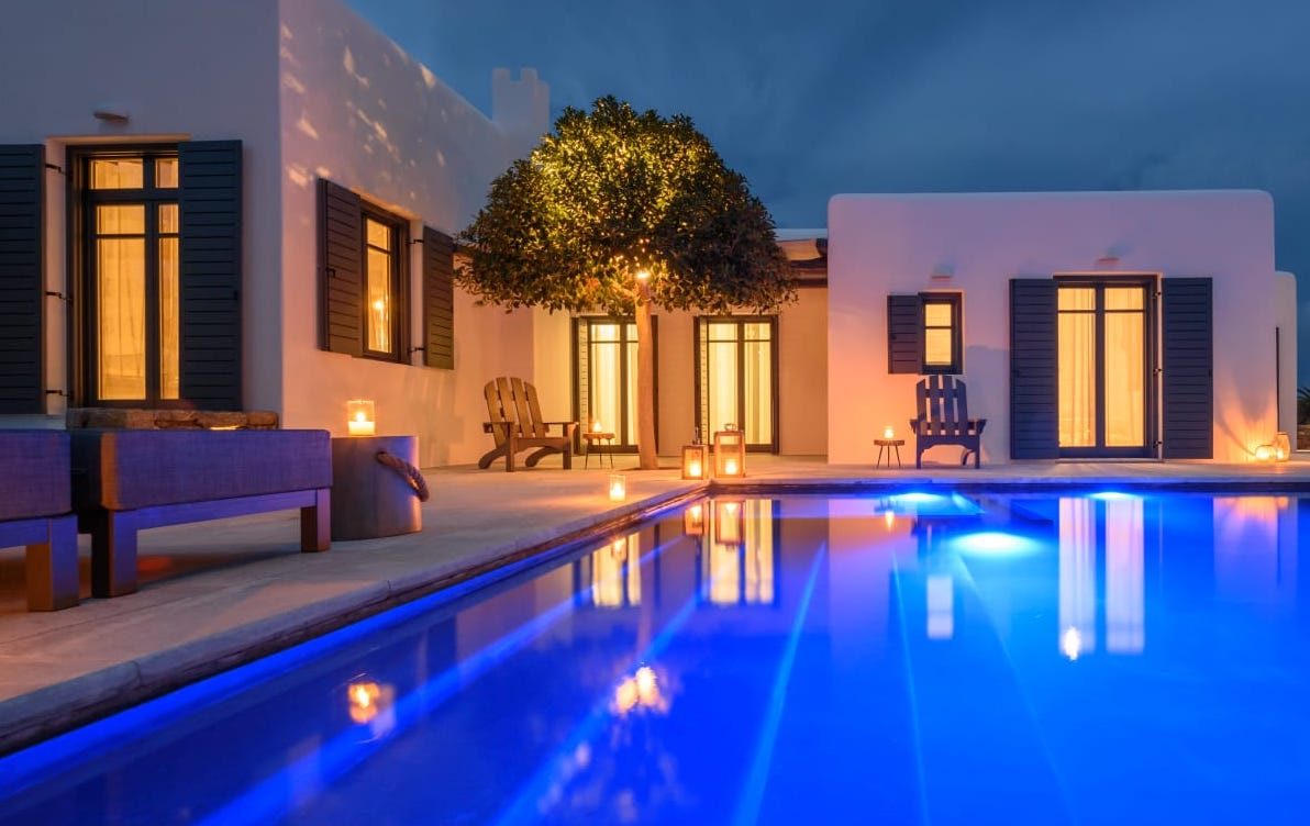 Villa and lit pool at dusk at Platinum Senior Villa in Kalafatis, Mykonos