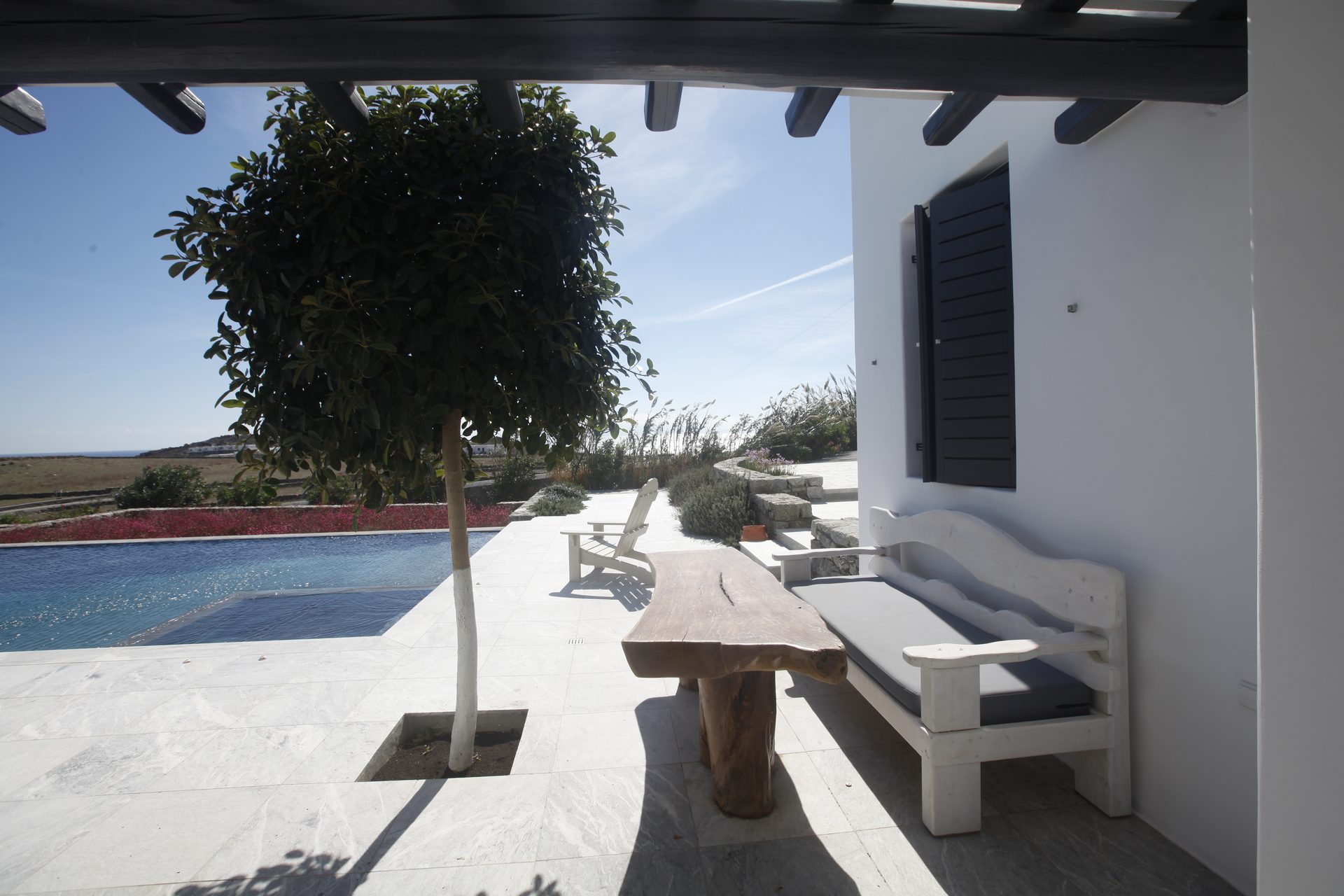 Shaded terrace with olive tree at Platinum Senior Villa in Kalafatis, Mykonos