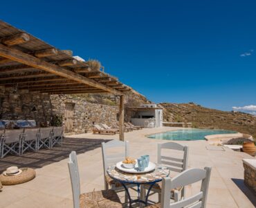 Pergola-covered outdoor dining with sea view at Tranquil Villa 5 in Kalafatis, Mykonos