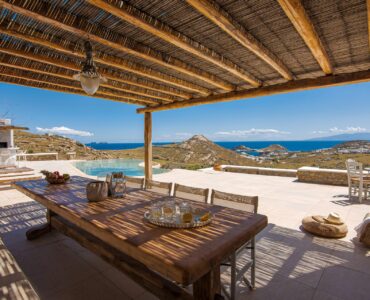 Dining table under the wooden pergola at Tranquil Villa 5 in Kalafatis, Mykonos
