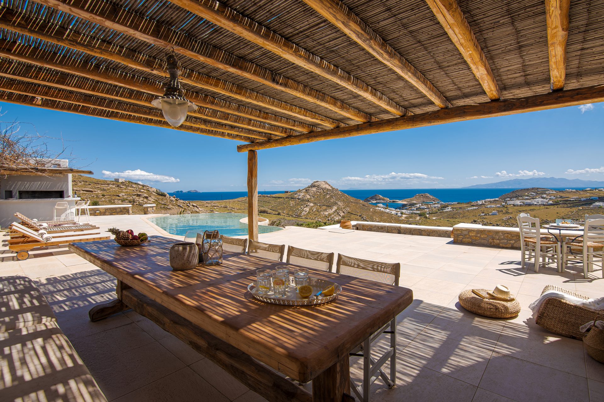Dining table under the wooden pergola at Tranquil Villa 5 in Kalafatis, Mykonos