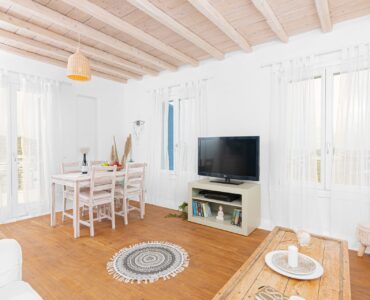 Living room with TV and dining table at Tranquil Villa 5 in Kalafatis, Mykonos