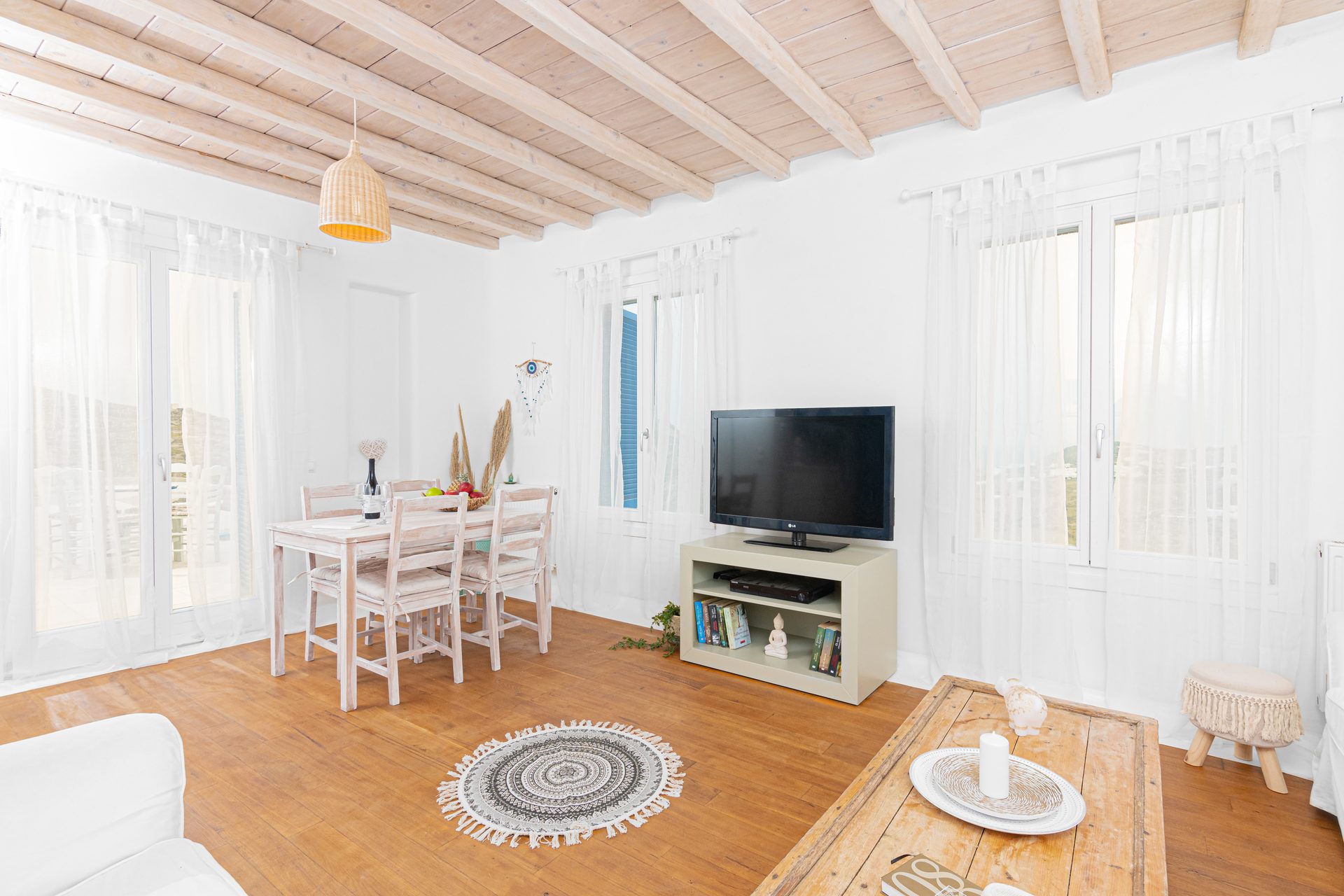 Living room with TV and dining table at Tranquil Villa 5 in Kalafatis, Mykonos