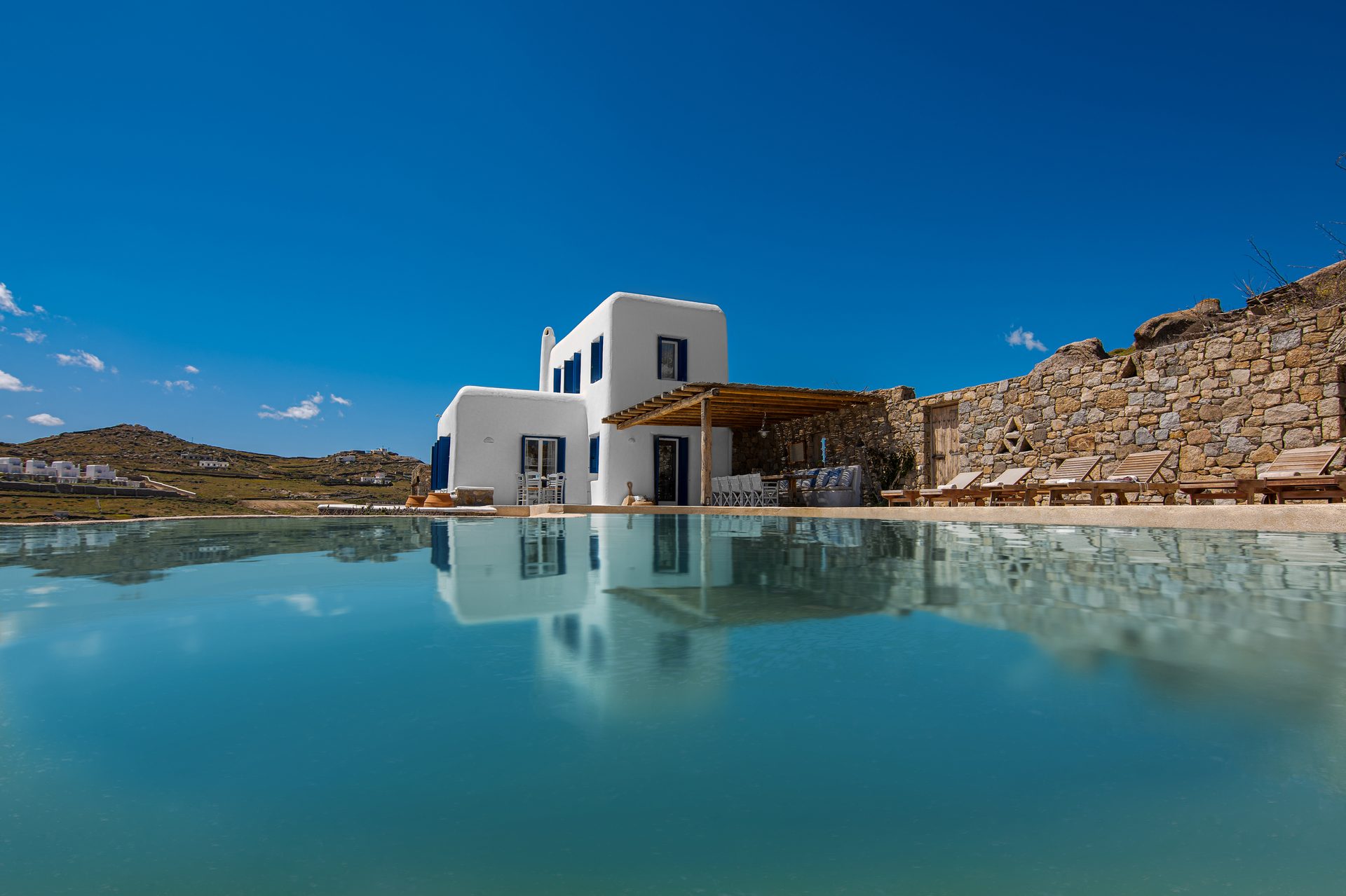 Pool and villa against the hills at Tranquil Villa 5 in Kalafatis, Mykonos