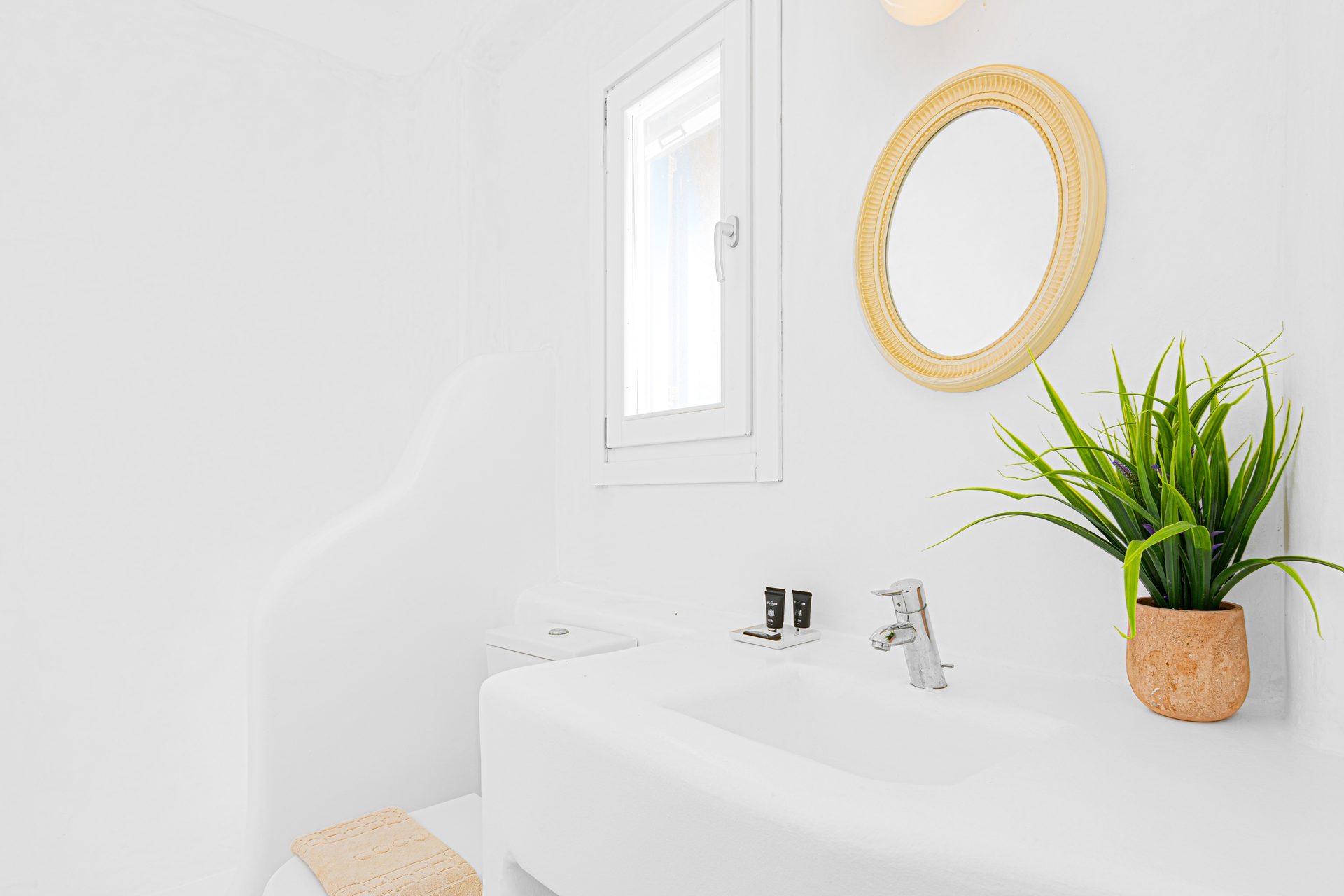 Bathroom with round mirror at Tranquil Villa 5 in Kalafatis, Mykonos