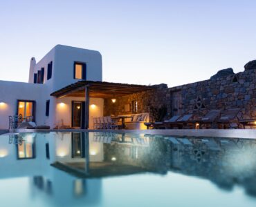 Villa reflected in the pool at dusk at Tranquil Villa 5 in Kalafatis, Mykonos