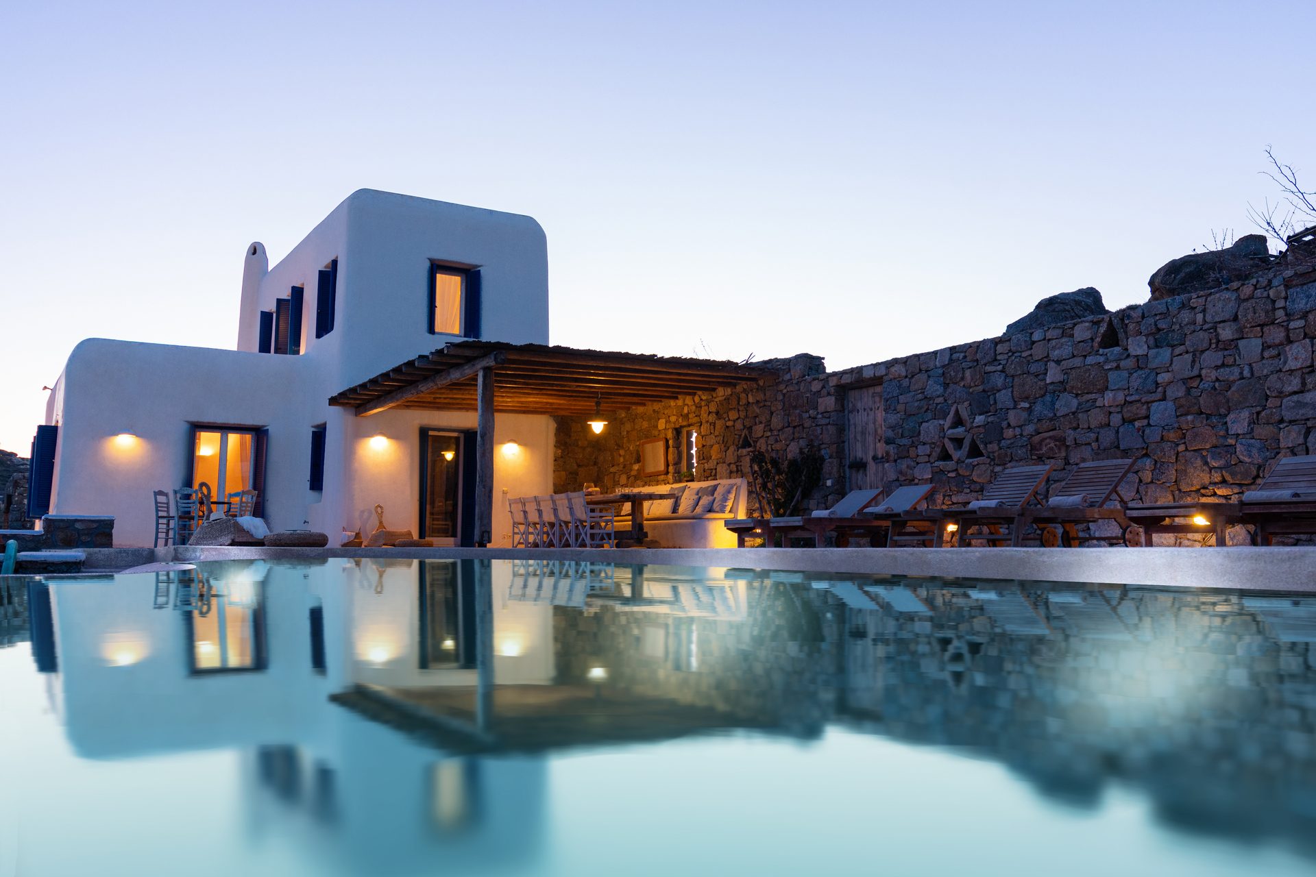 Villa reflected in the pool at dusk at Tranquil Villa 5 in Kalafatis, Mykonos