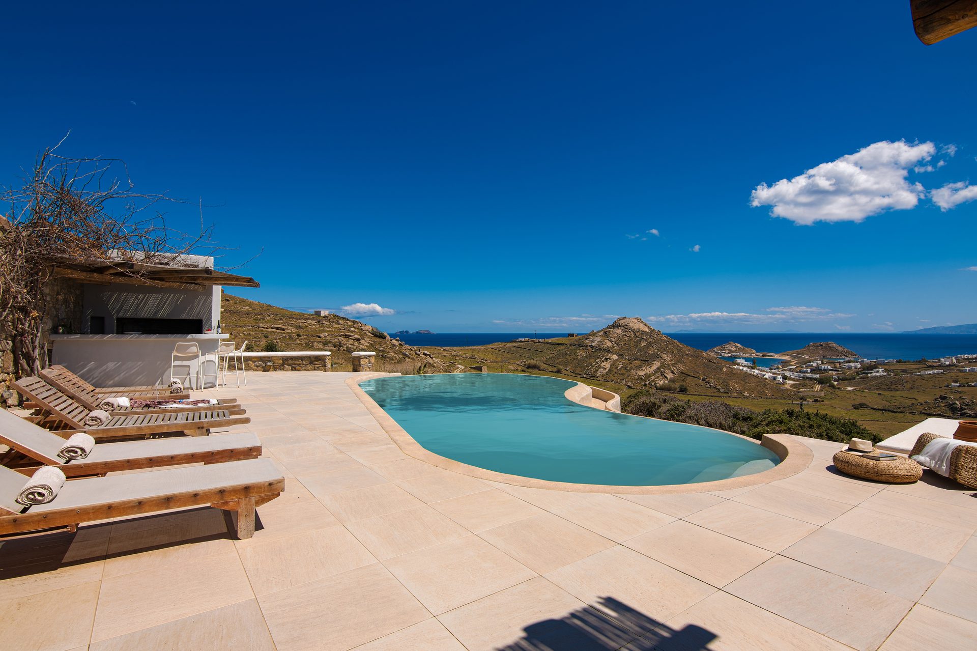 Sun loungers by the pool at Tranquil Villa 5 in Kalafatis, Mykonos