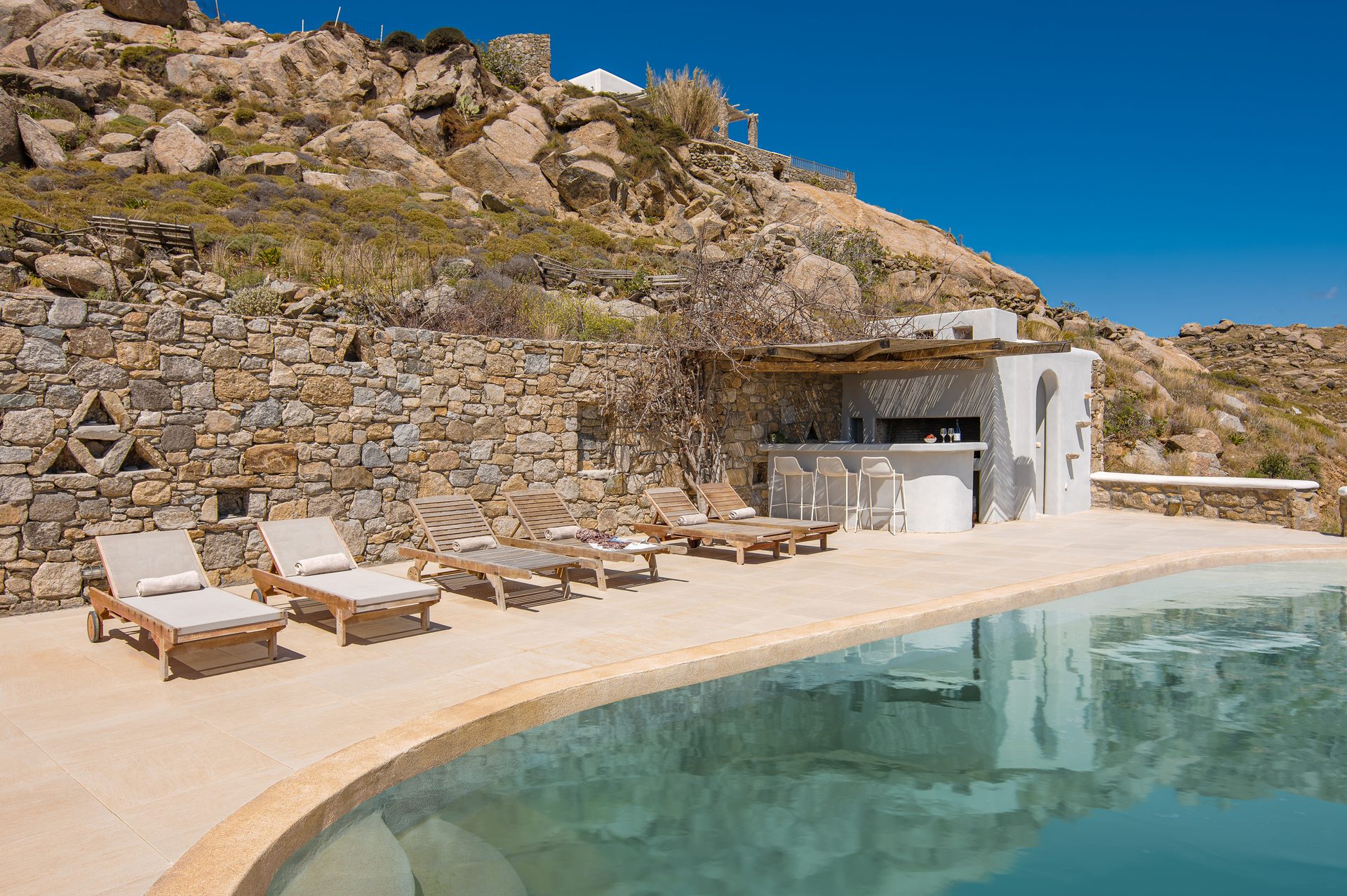 Pool, sun loungers and stone terraces at Tranquil Villa 5 in Kalafatis, Mykonos