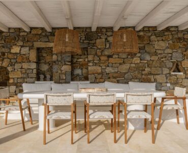 Outdoor dining area under a wooden pergola at Villa Alkioni in Agios Lazaros, Mykonos