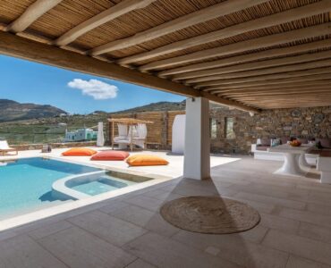 Pool and shaded pergola overlooking the hills at Villa Aloni in Ftelia, Mykonos
