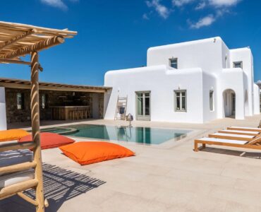 Pool terrace with lounge cushions and pergola at Villa Aloni in Ftelia, Mykonos