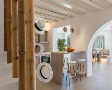 Living room and kitchen under a Cycladic arch at Villa Aloni in Ftelia, Mykonos