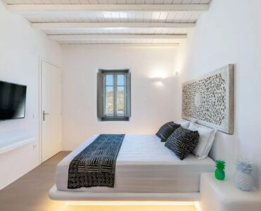 Double bedroom with carved headboard at Villa Aloni in Ftelia, Mykonos