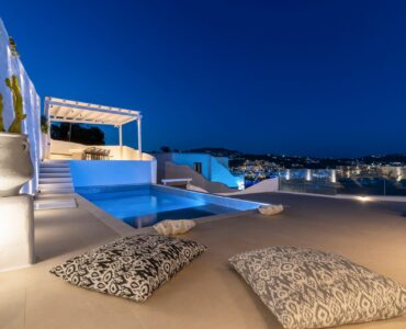 Pool and Psarou bay at dusk at Villa Aquablue in Agios Lazaros, Mykonos