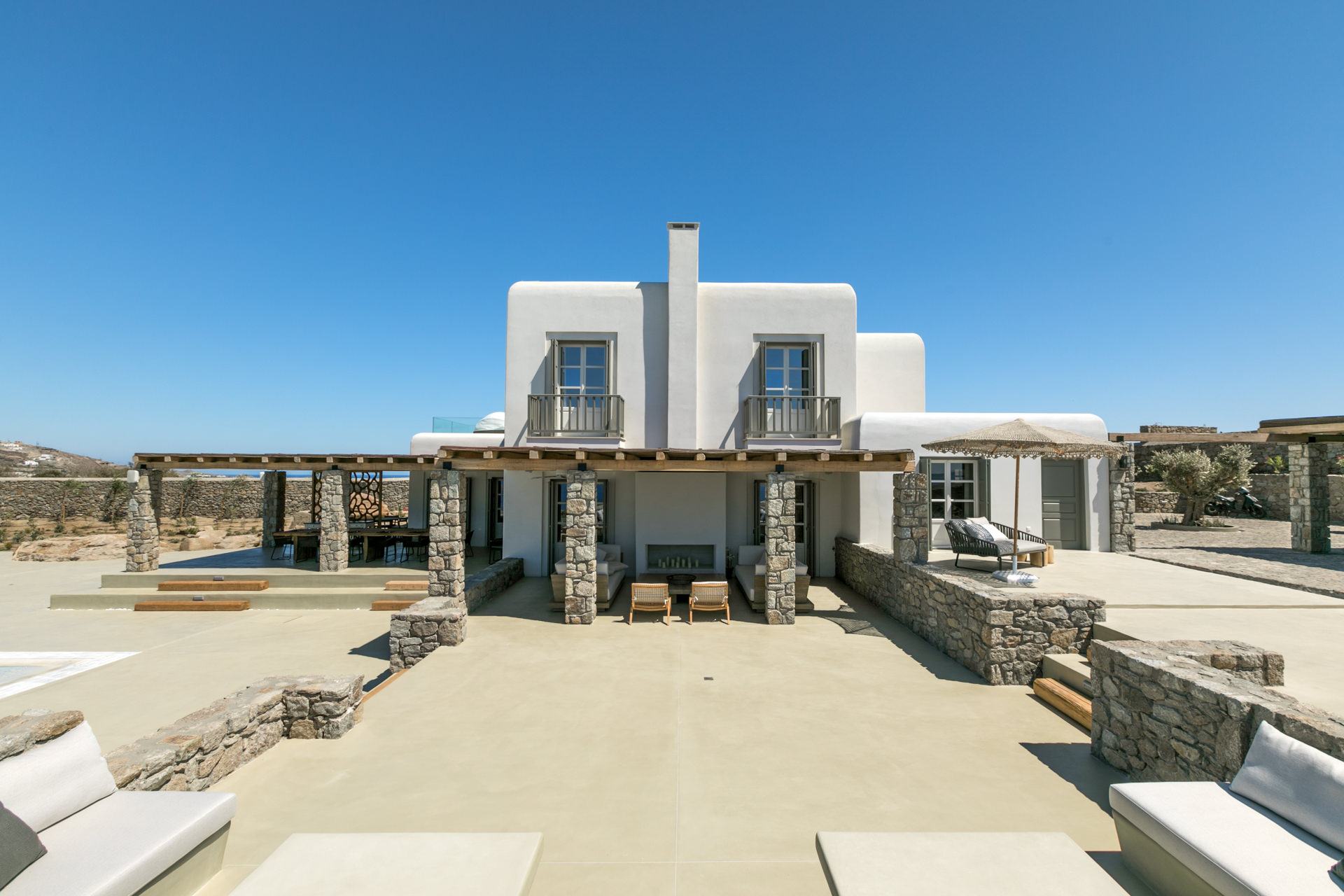 Main house with covered terraces and pool at Villa Arion in Aleomandra, Mykonos