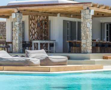 Sun loungers by the pool and covered terrace at Villa Arion in Aleomandra, Mykonos