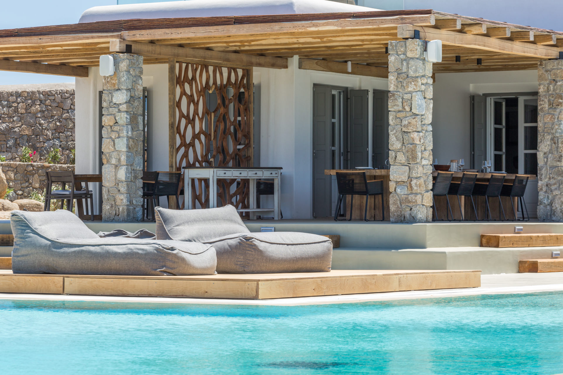 Sun loungers by the pool and covered terrace at Villa Arion in Aleomandra, Mykonos