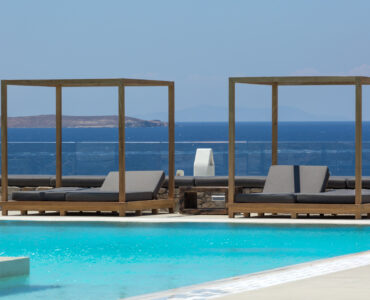 Sea-view daybeds beside the pool at Villa Arion in Aleomandra, Mykonos