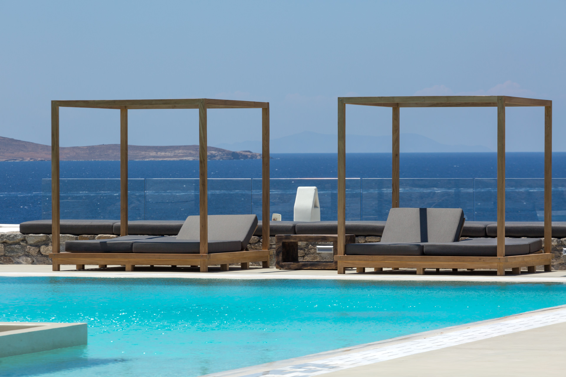 Sea-view daybeds beside the pool at Villa Arion in Aleomandra, Mykonos