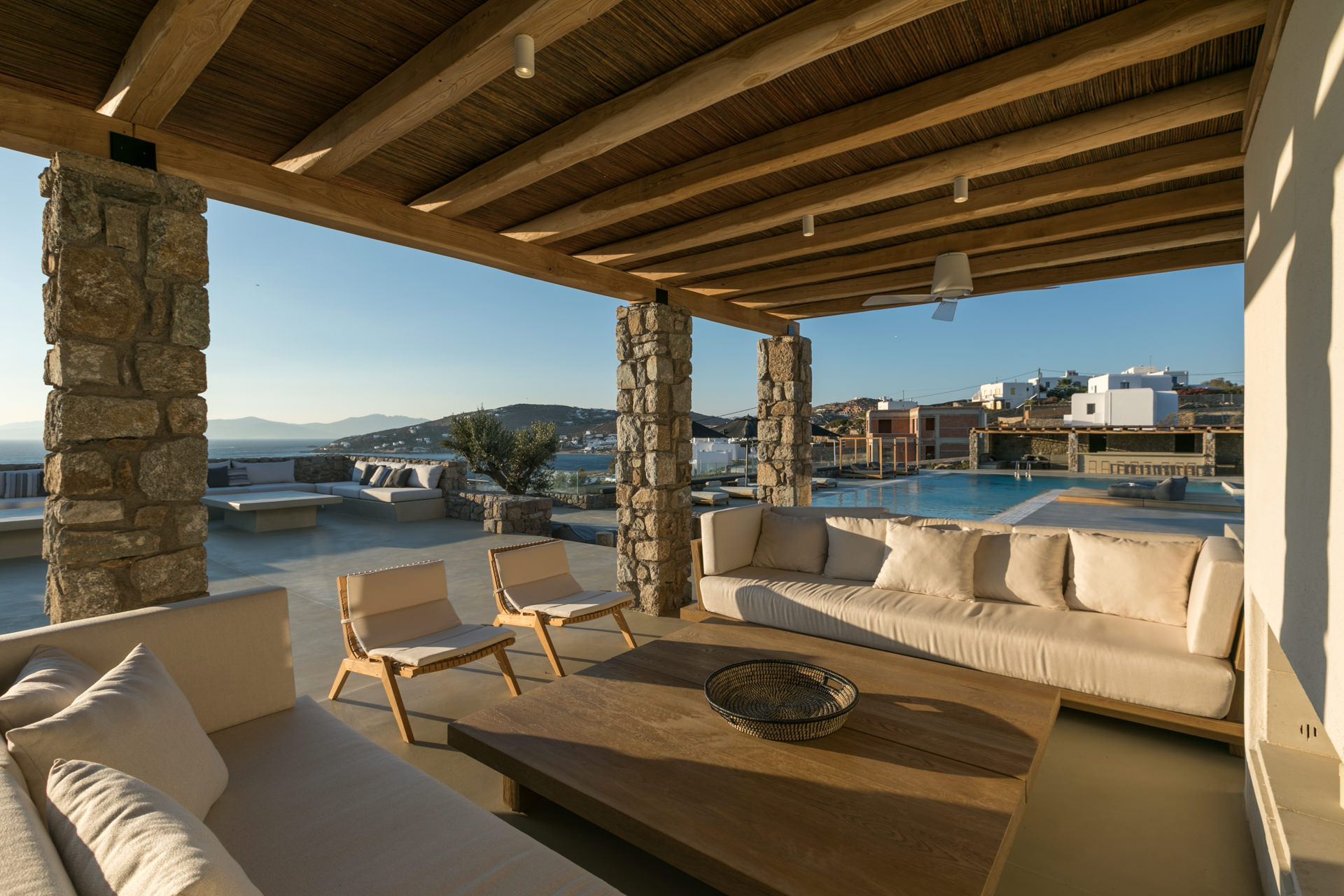Covered outdoor lounge facing the pool at Villa Arion in Aleomandra, Mykonos