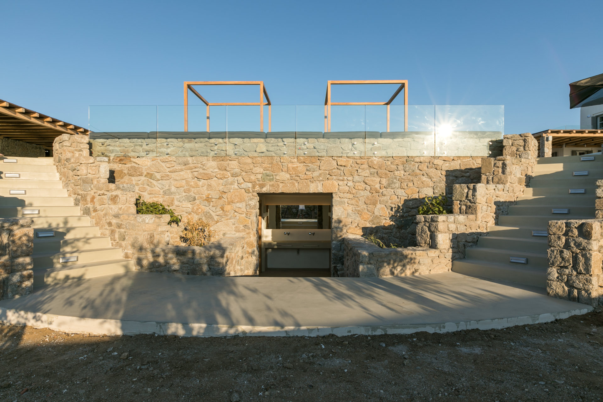 Stone-built BBQ area below the pool terrace at Villa Arion in Aleomandra, Mykonos