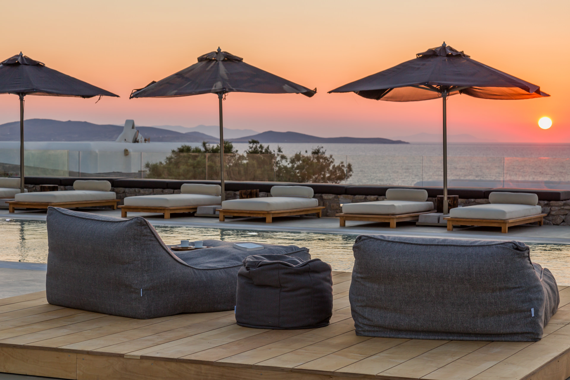 Bean bags and sun loungers at sunset at Villa Arion in Aleomandra, Mykonos
