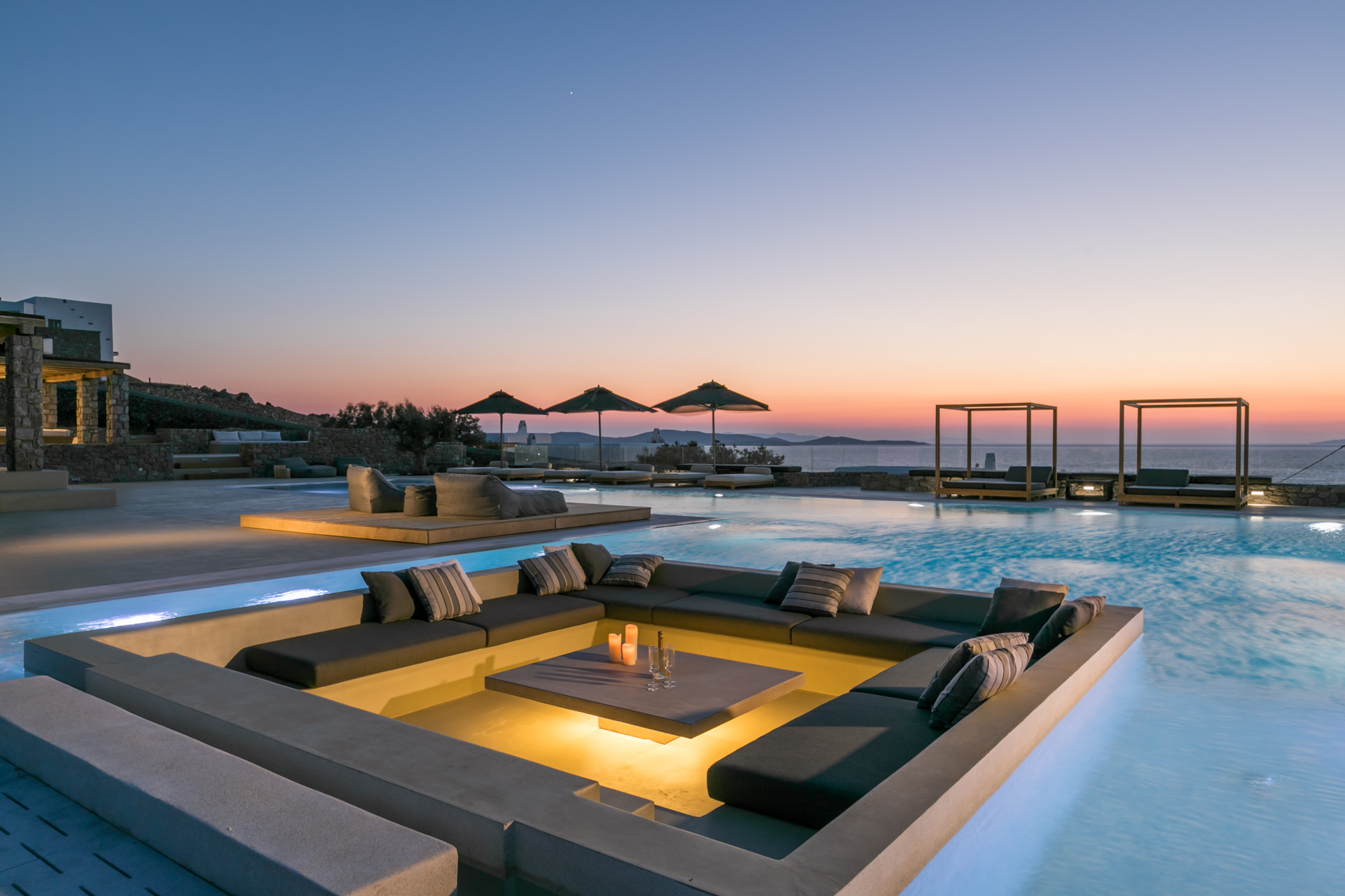 Sunken pool lounge lit at dusk at Villa Arion in Aleomandra, Mykonos